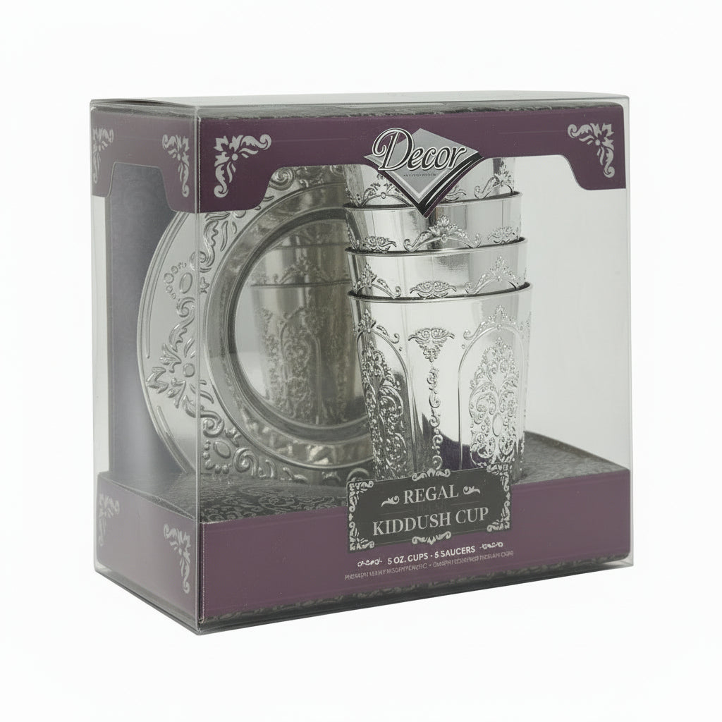 A set of five Decor Regal Kiddush cups and plates, packaged in a clear box with a purple and white decorative border. The cups and plates have a silver color with intricate designs.