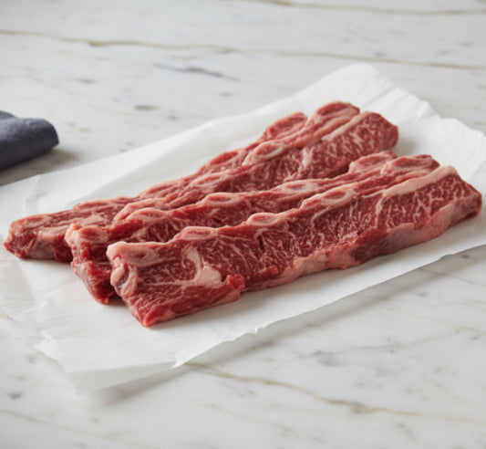 Raw beef strips on a white paper with a blue fabric background